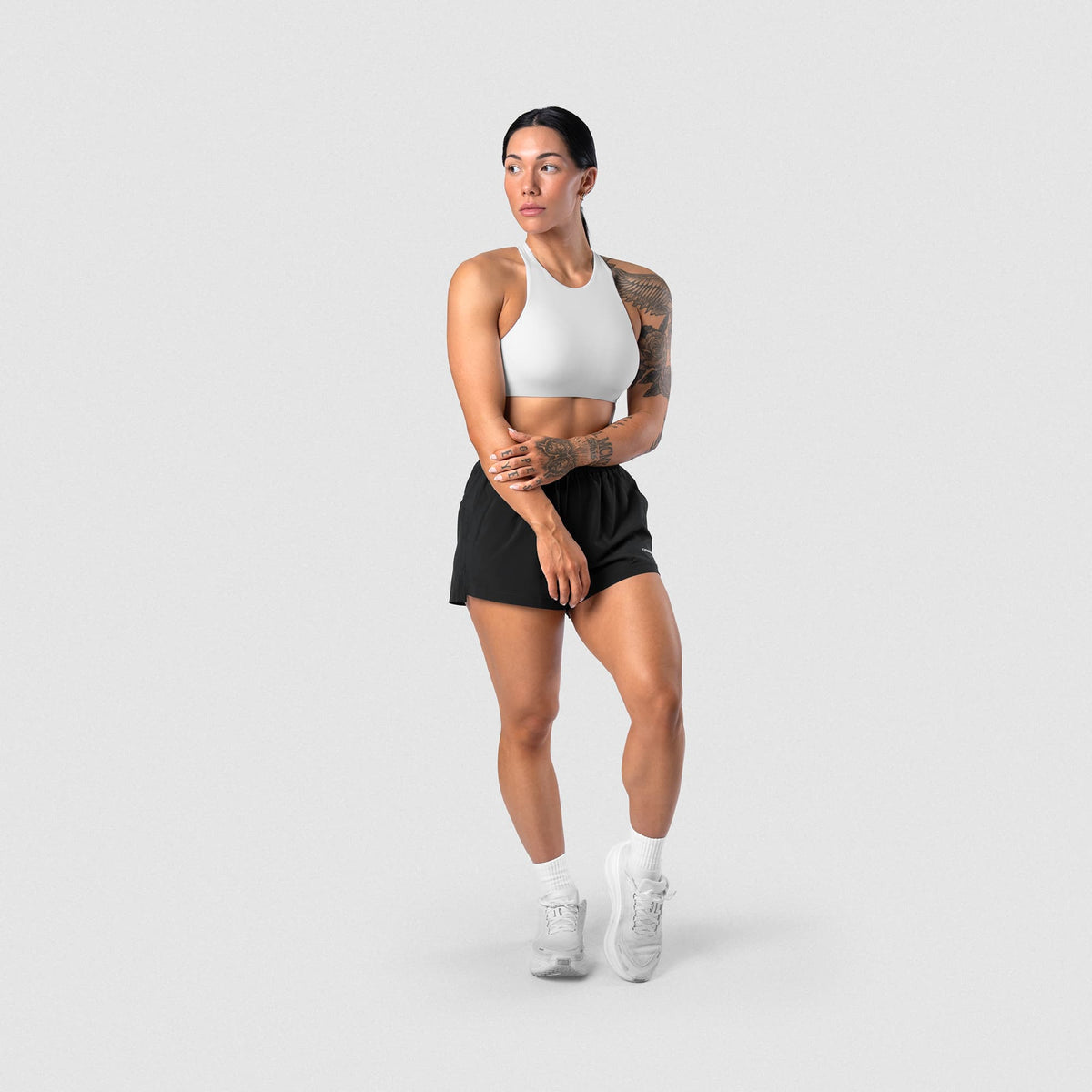 Female model wearing the Axis High Neck Bra - White full-body view