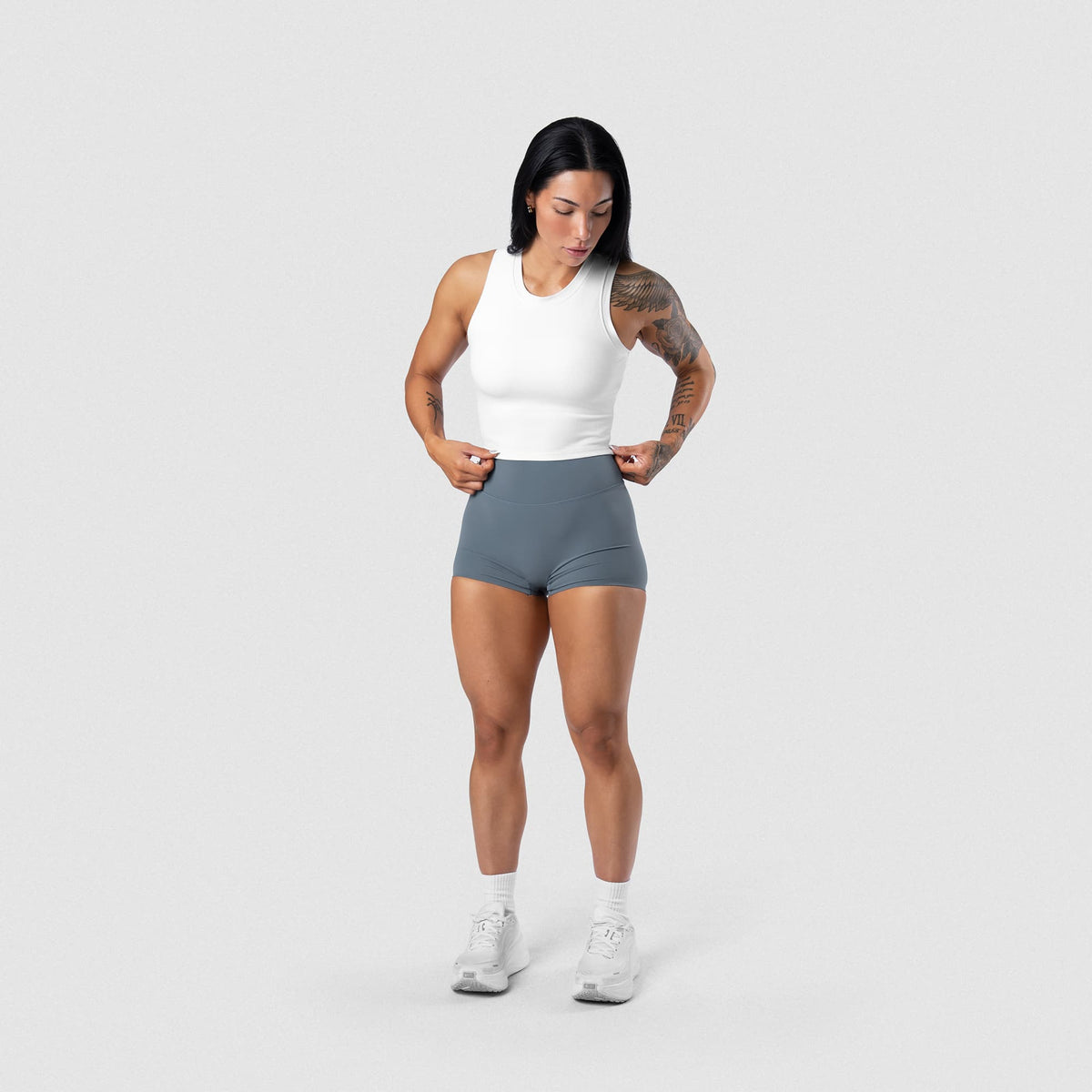 Female model wearing the Axis Support Tank - White full-body view