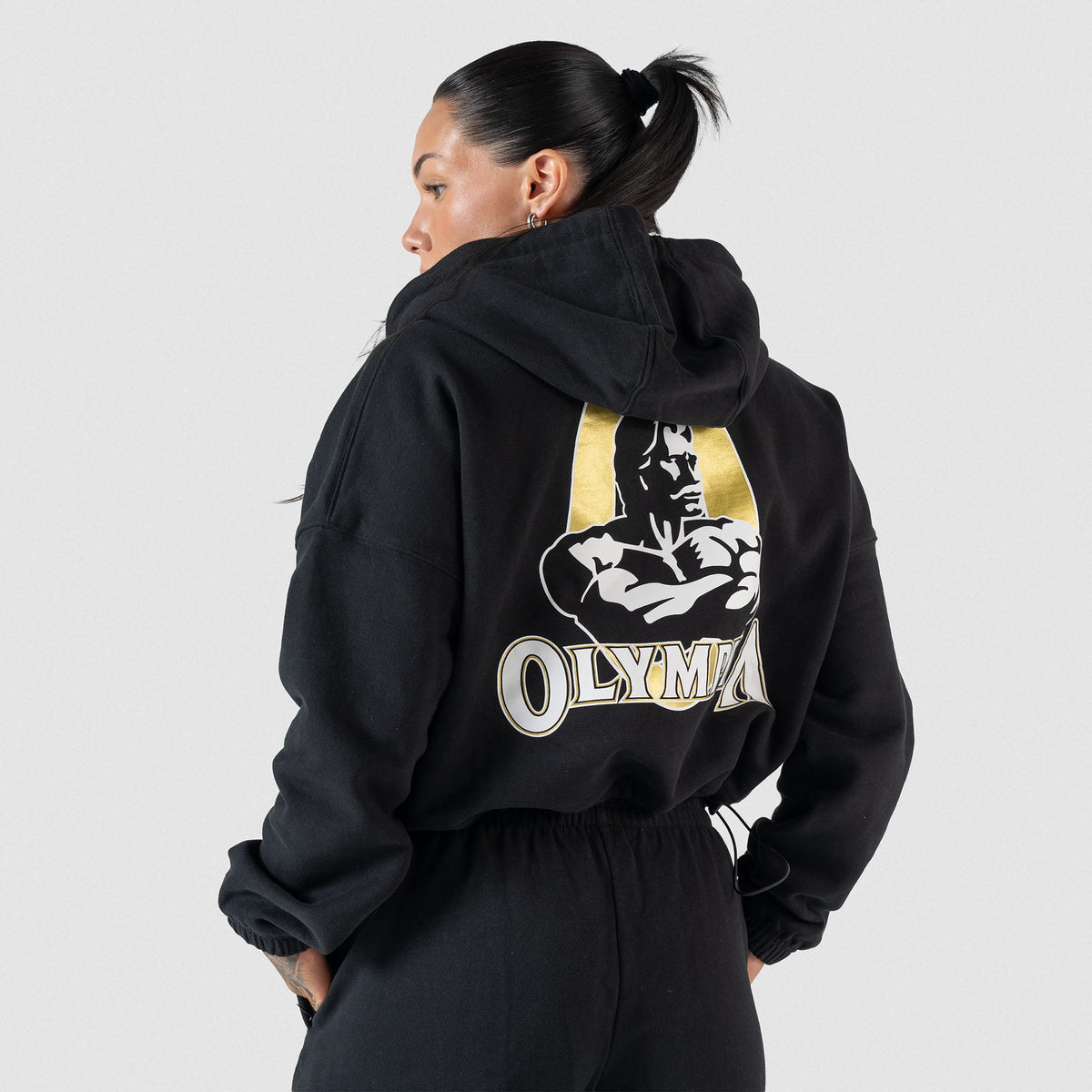 Champions Gold Cropped Zip-Up Hoodie | Back view, on model showcasing the large Gold and White Olympia Logo