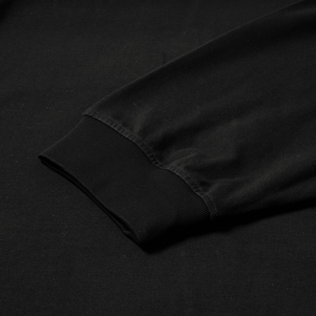 7. Close-up of black sleeve cuff and hem detail