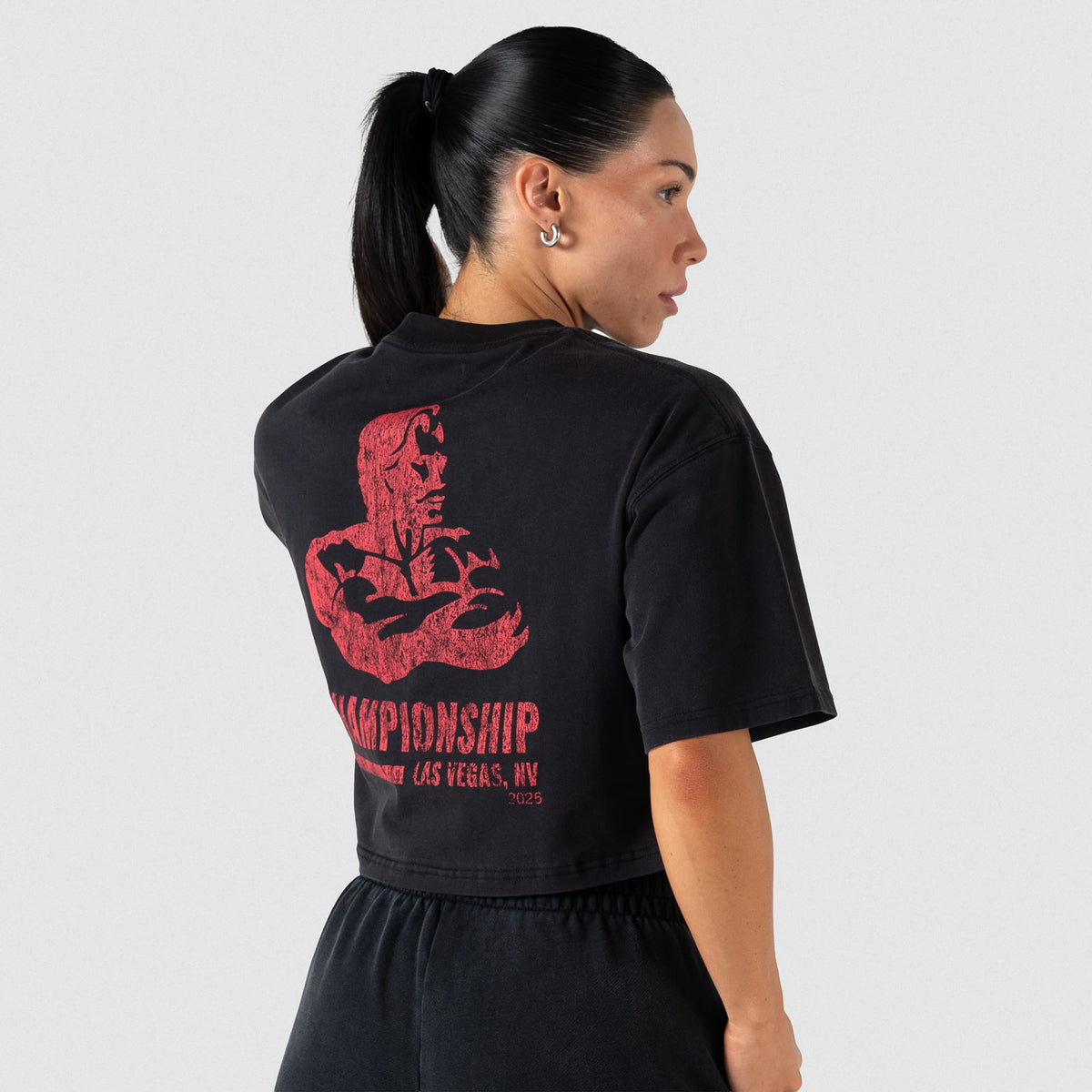 Back view of the women's black Championship Crop Tee on a female model, showcasing the large back graphic