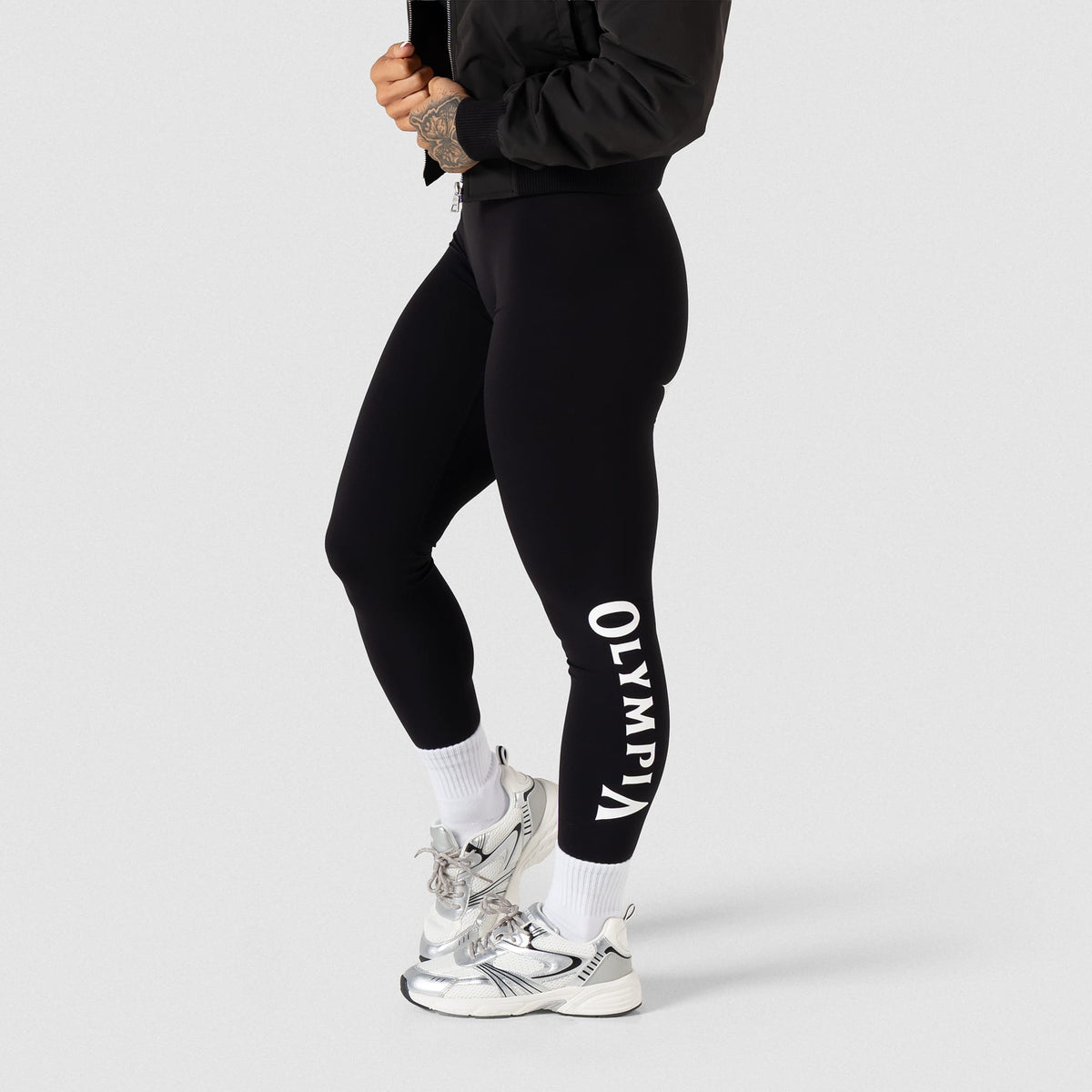 Side view of the Women's Olympia Legging in Black showing the "Olympia" wordmark text in black along the side of the calf