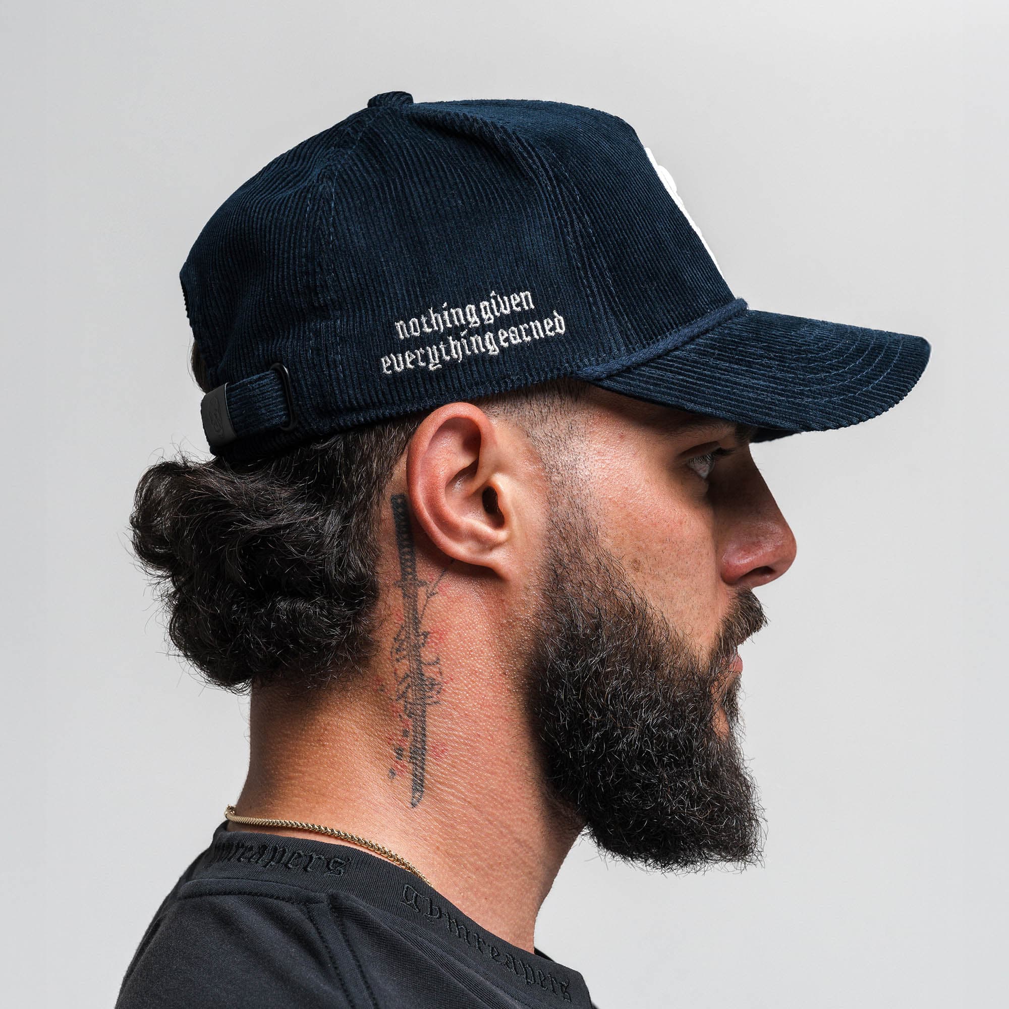 Athlete wearing Corduroy 5-Panel Skull Hat - Navy/Cream side view