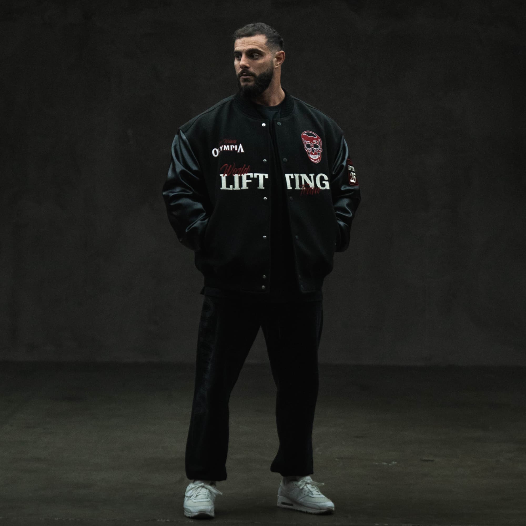 Model full-body front view wearing the Racing Team Varsity Jacket with front chest and sleeve details.