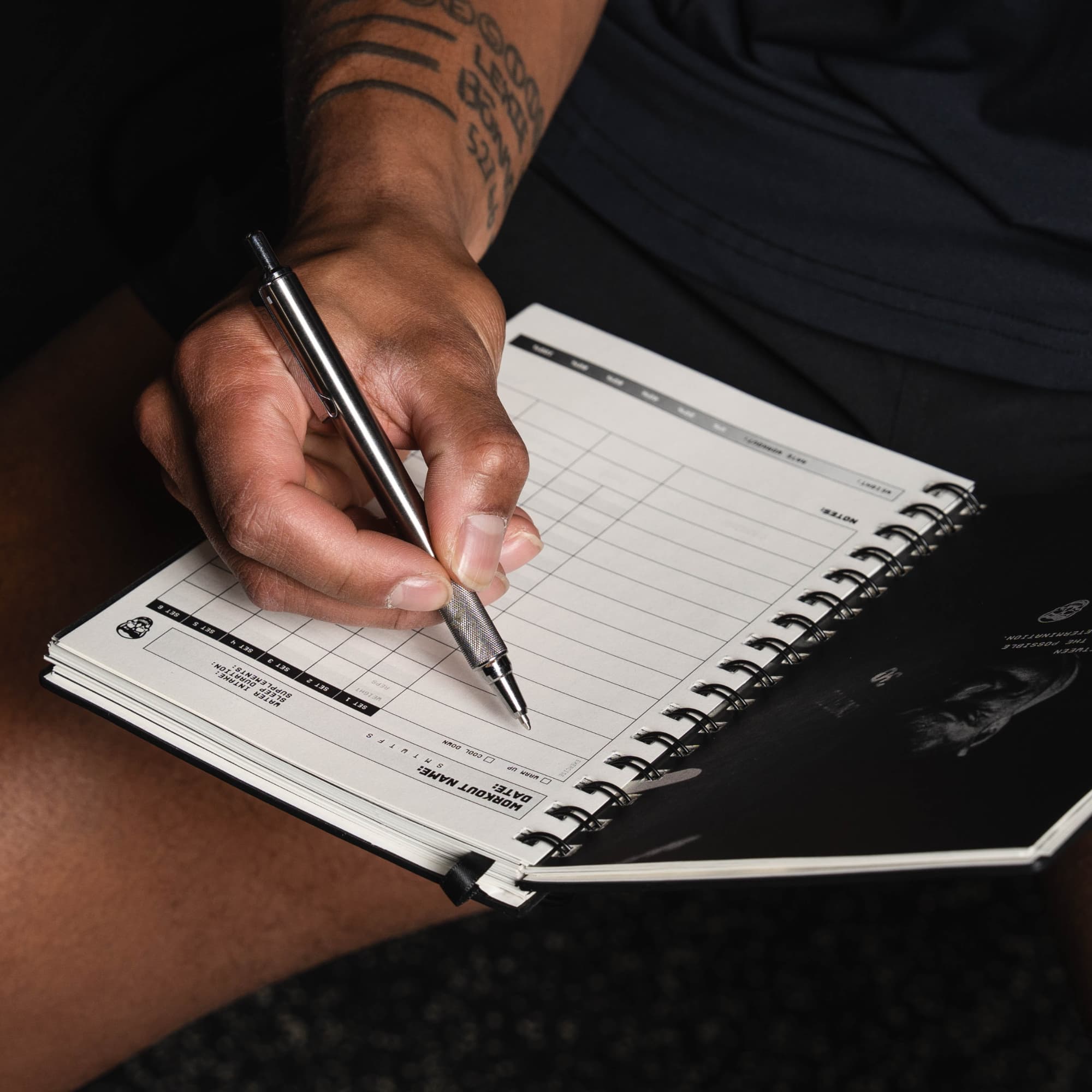 shot of athlete writing in workout journal