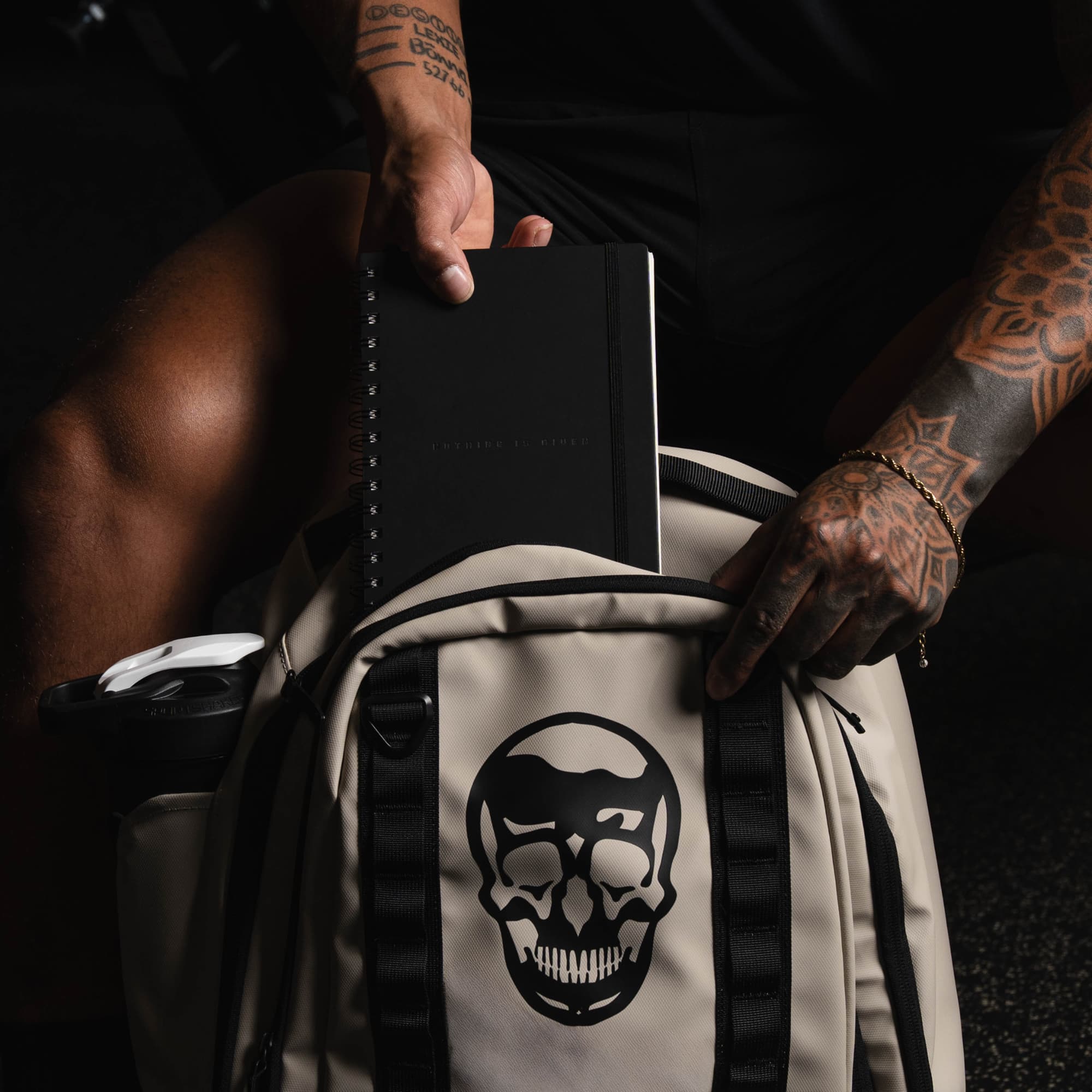 shot of athlete putting workout journal in backpack