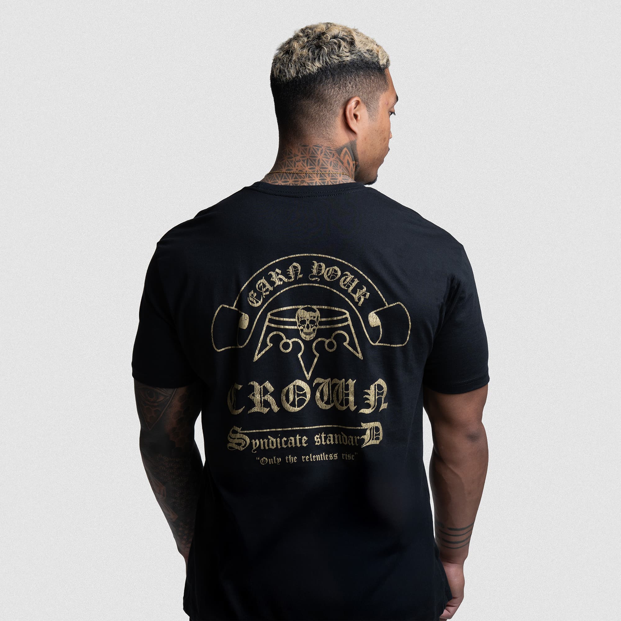 Athlete wearing the Earn Your Crown Tee, showcasing detailed gold graphic and "Only the relentless rise" quote on the back.