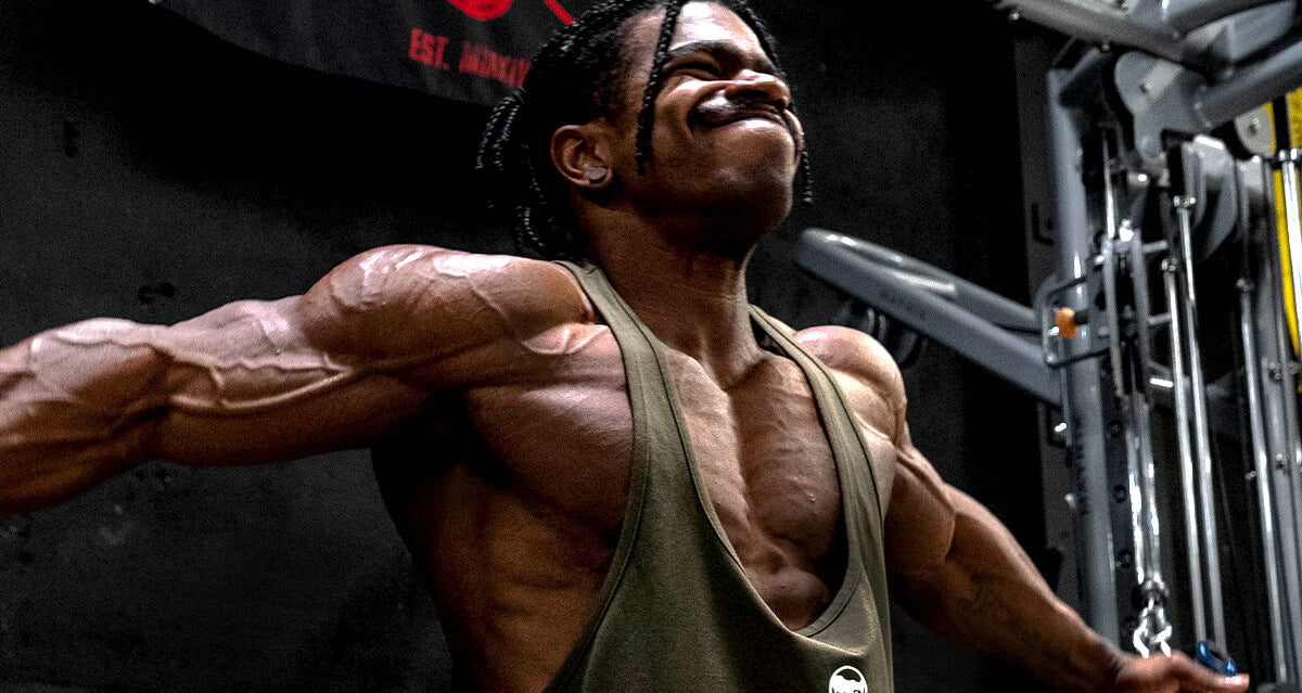 Man with large pecs doing cable fly exercise in a gym.