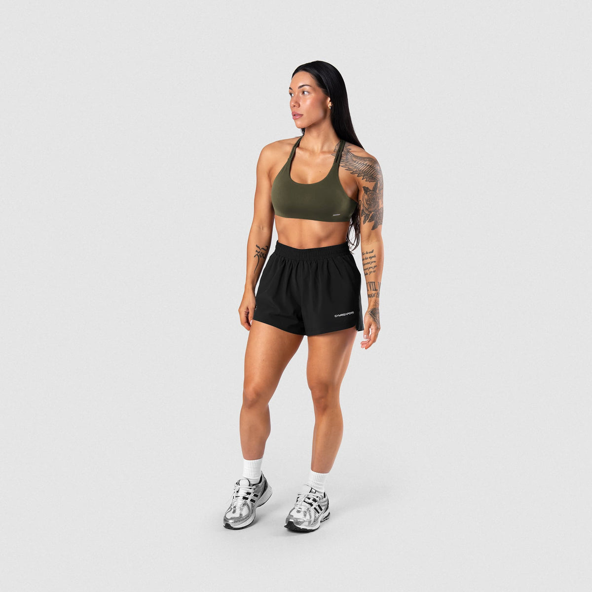Female model wearing the Axis Open Back Bra - OD Green full-body view