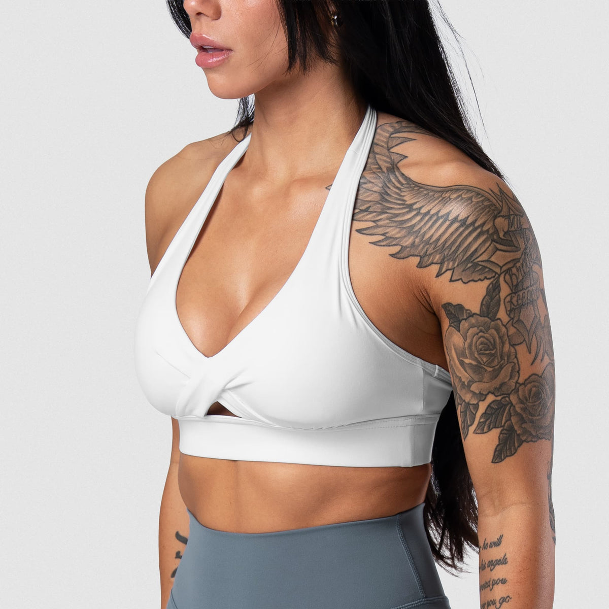 Female model wearing the Axis Twisted Halter Bra - White side view