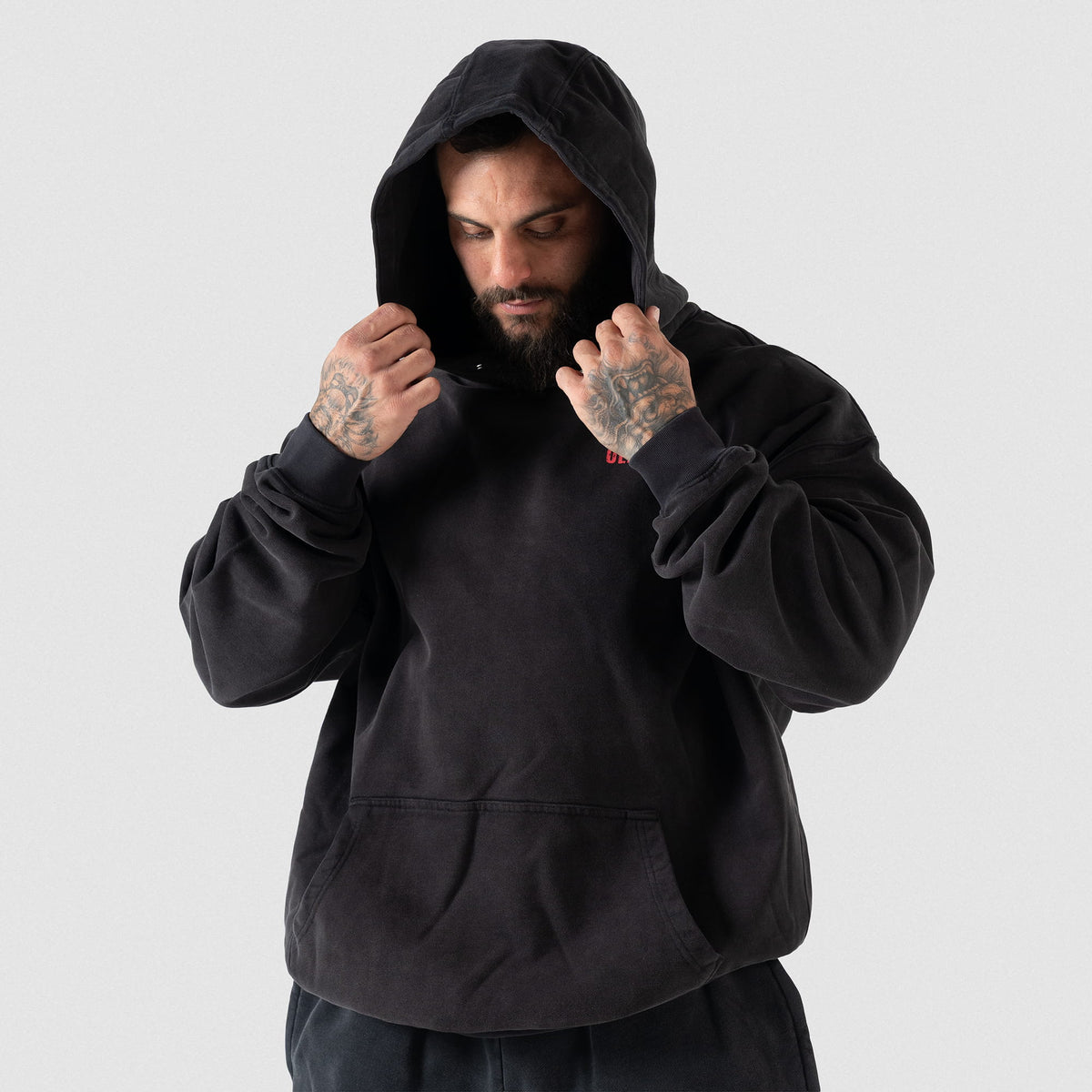 Championship Hoodie | Male model pulling up the hood of the black Championship hoodie