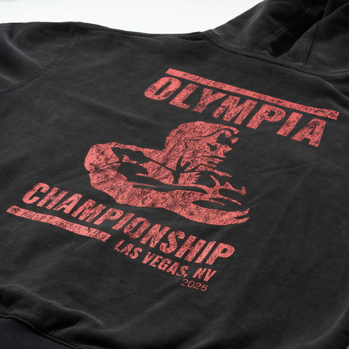 Championship Hoodie | Back graphic of hoodie showing red text "Olympia" at the top, and "Championship Las Vegas, NV 2026" at the bottom, with a red Olympia logo in between the text