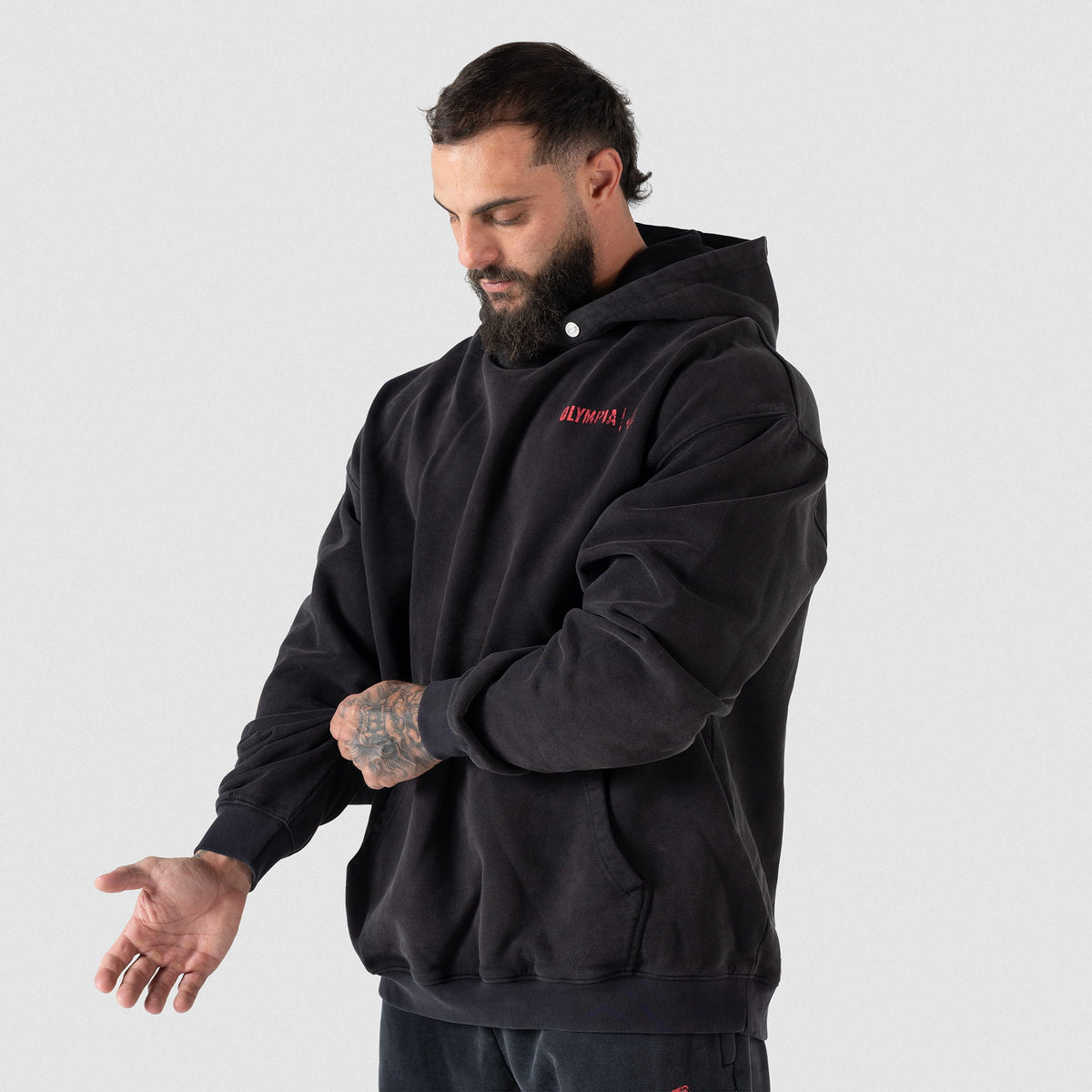 Championship Hoodie | Male model adjusting his sleeves, angled slightly toward the camera