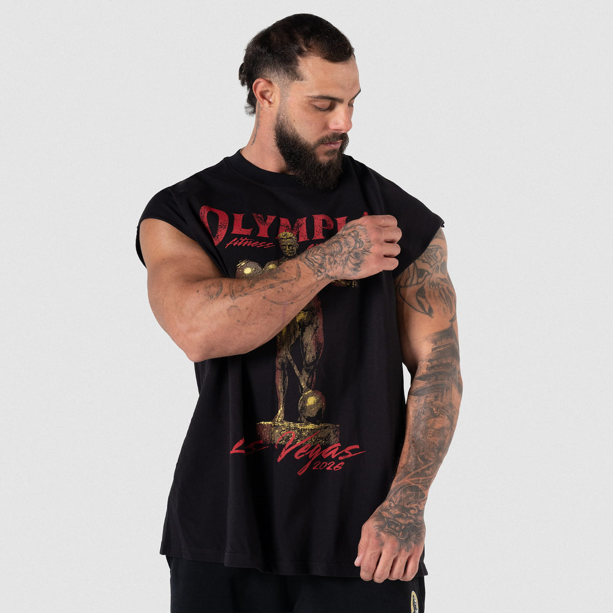 Male model adjusting the front sleeve of the Olympia 2026 Sandow Cut-Off