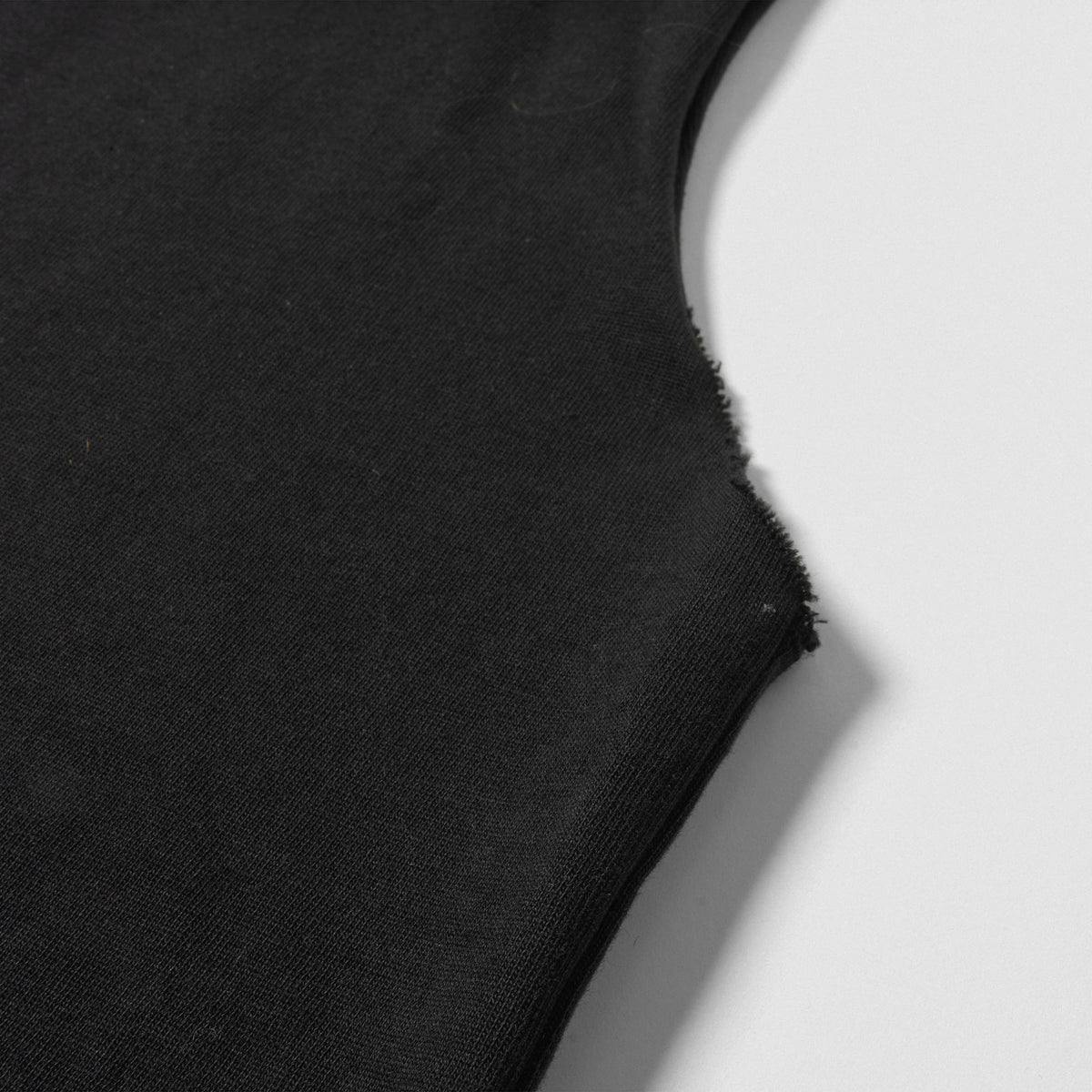 Close up of raw hem on the sleeves of the Olympia 2026 Sandow Cut-Off tank