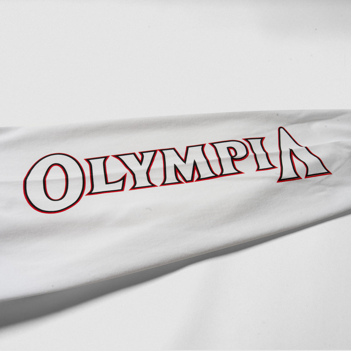 Close up of sleeve logo on the Signature Long Sleeve Tee in white with the Olympia wordmark