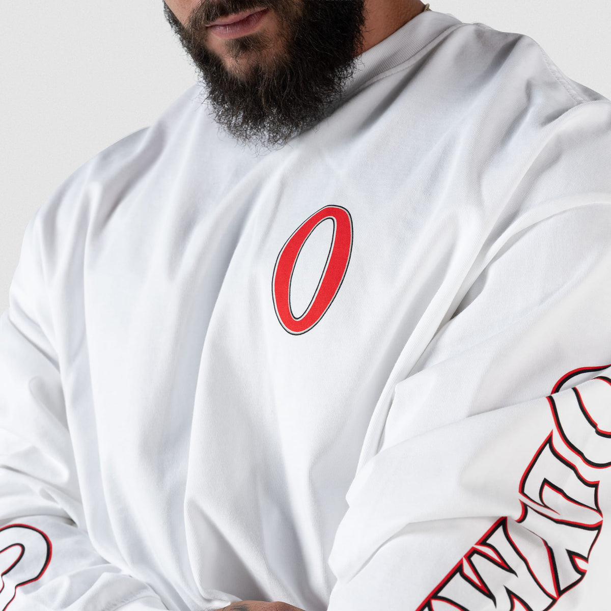Close up of red "O" chest logo on the Signature Long Sleeve Tee in white