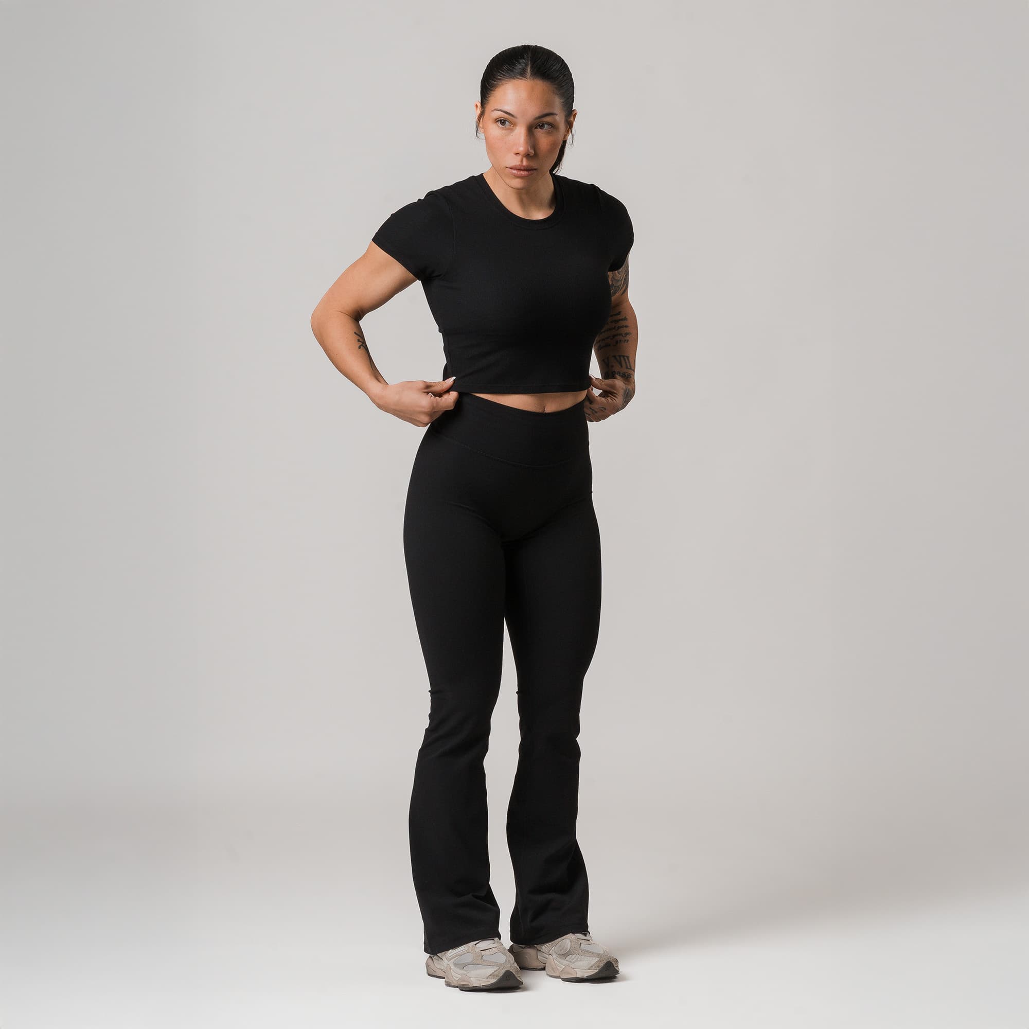 athlete wearing black axis flare leggings full body shot front view