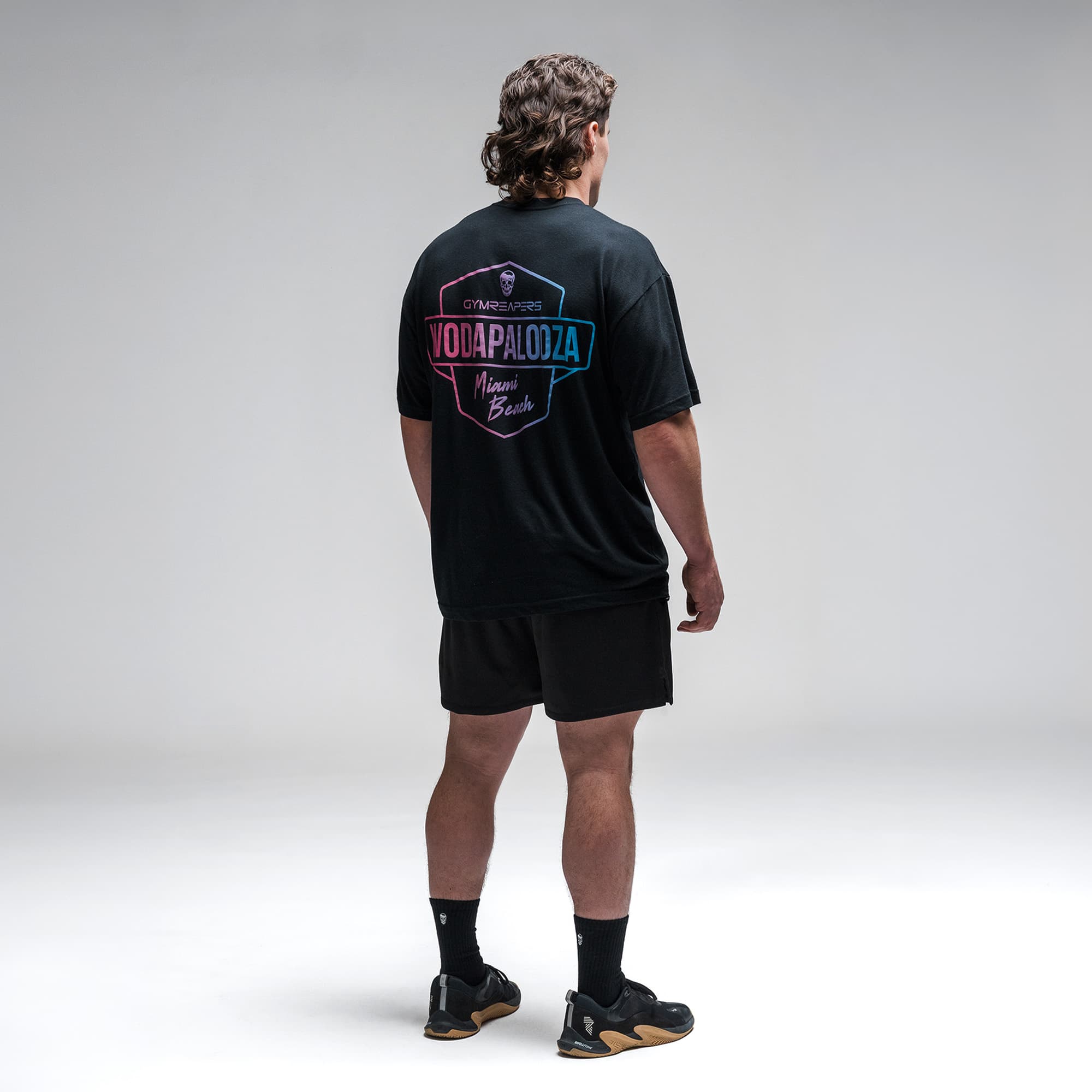 Athlete wearing the Gymreapers WZA Shield Tee full body shot back view