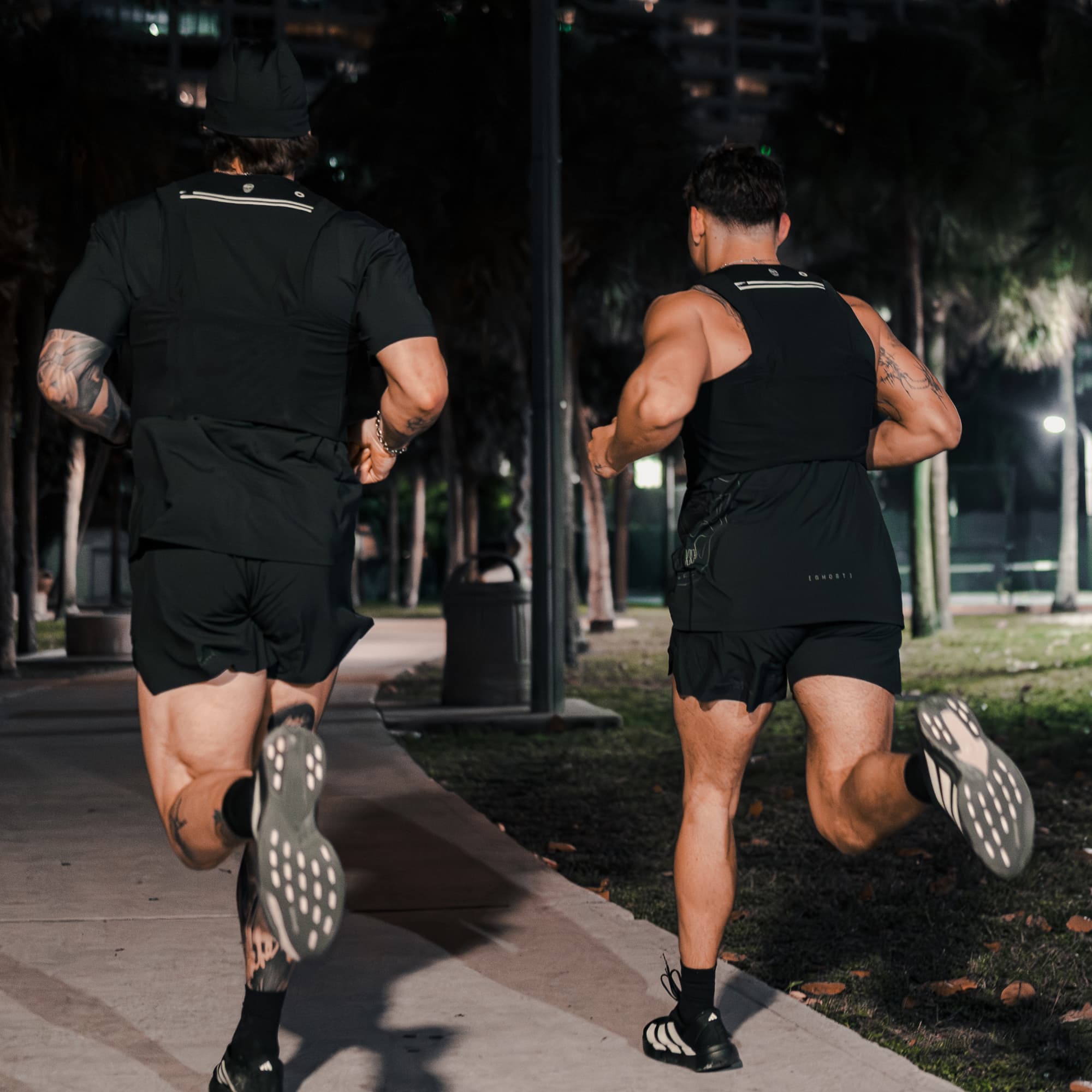 Lifestyle shot of athletes running away from the camera wearing the Ghost 5" Run Shorts