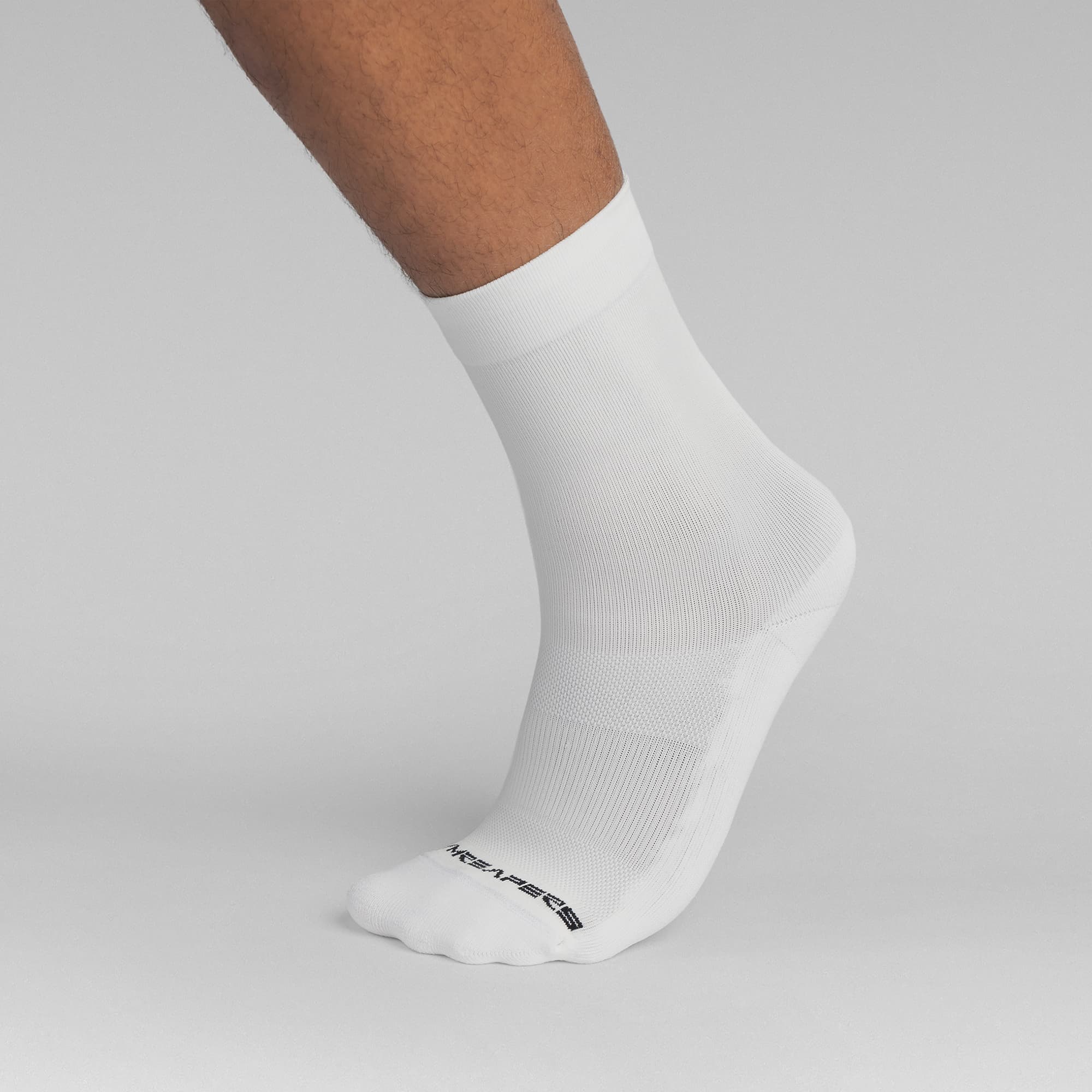 Athlete wearing the White Stryda™ Crew Run Socks side view taking step