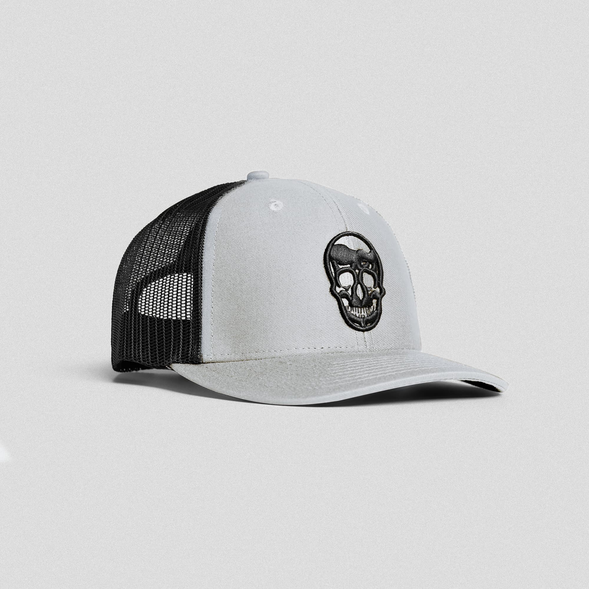 Front view of Gymreapers slate trucker hat with embroidered skull logo