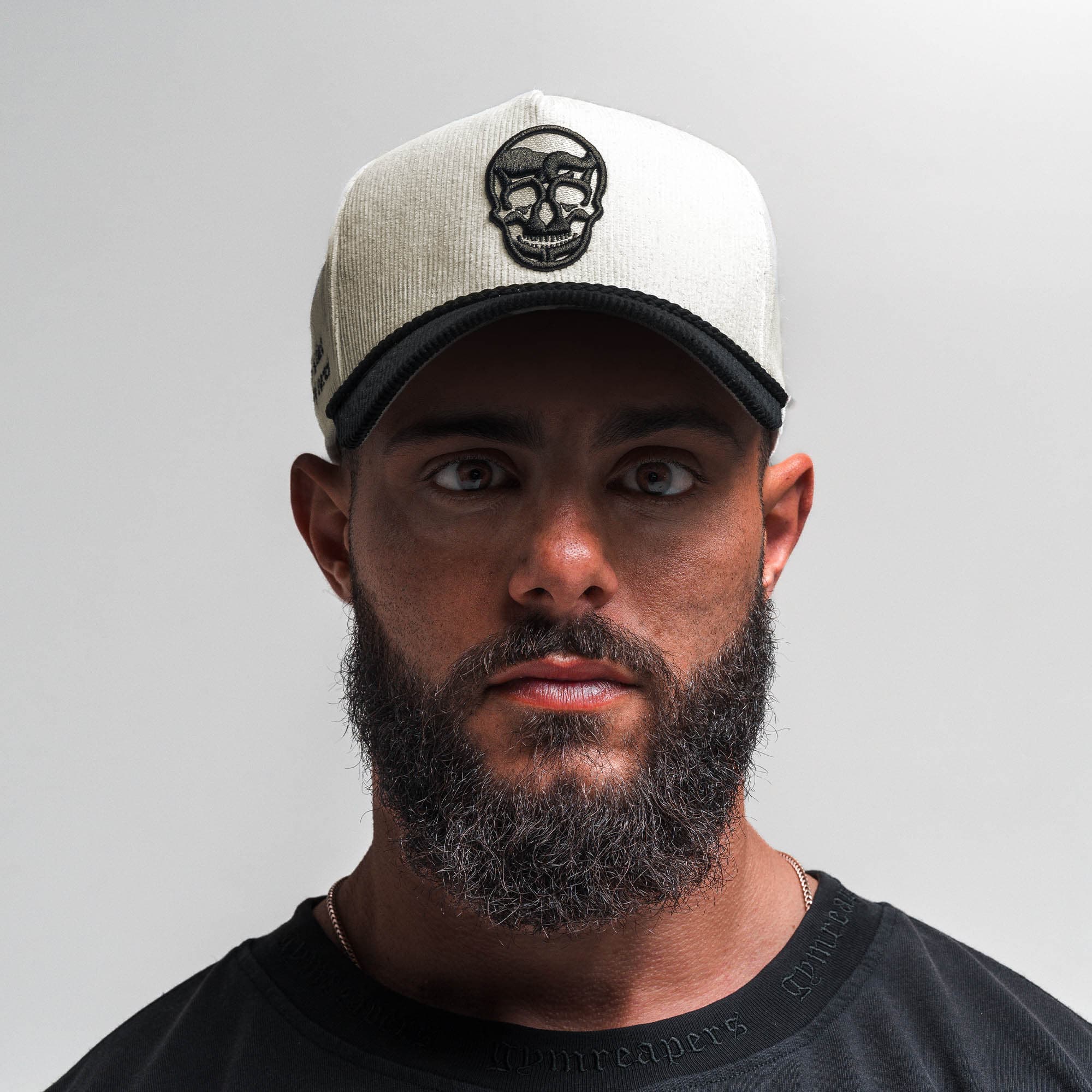 Athlete wearing Corduroy 5-Panel Skull Hat - Cream/Black front view