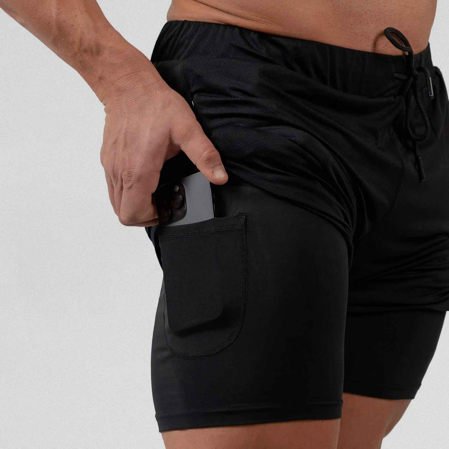 Gymreapers react training shorts black with athlete wearing them, zoomed in to hidden pocket side on liner.