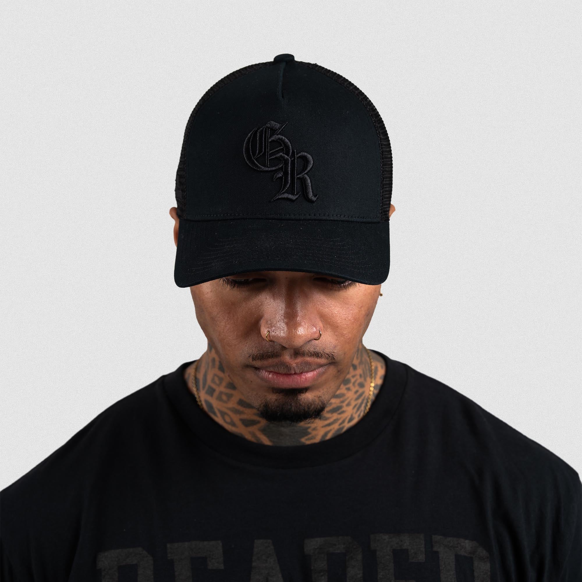 Athlete wearing Black/Black 5-Panel Initial Trucker Hat front view