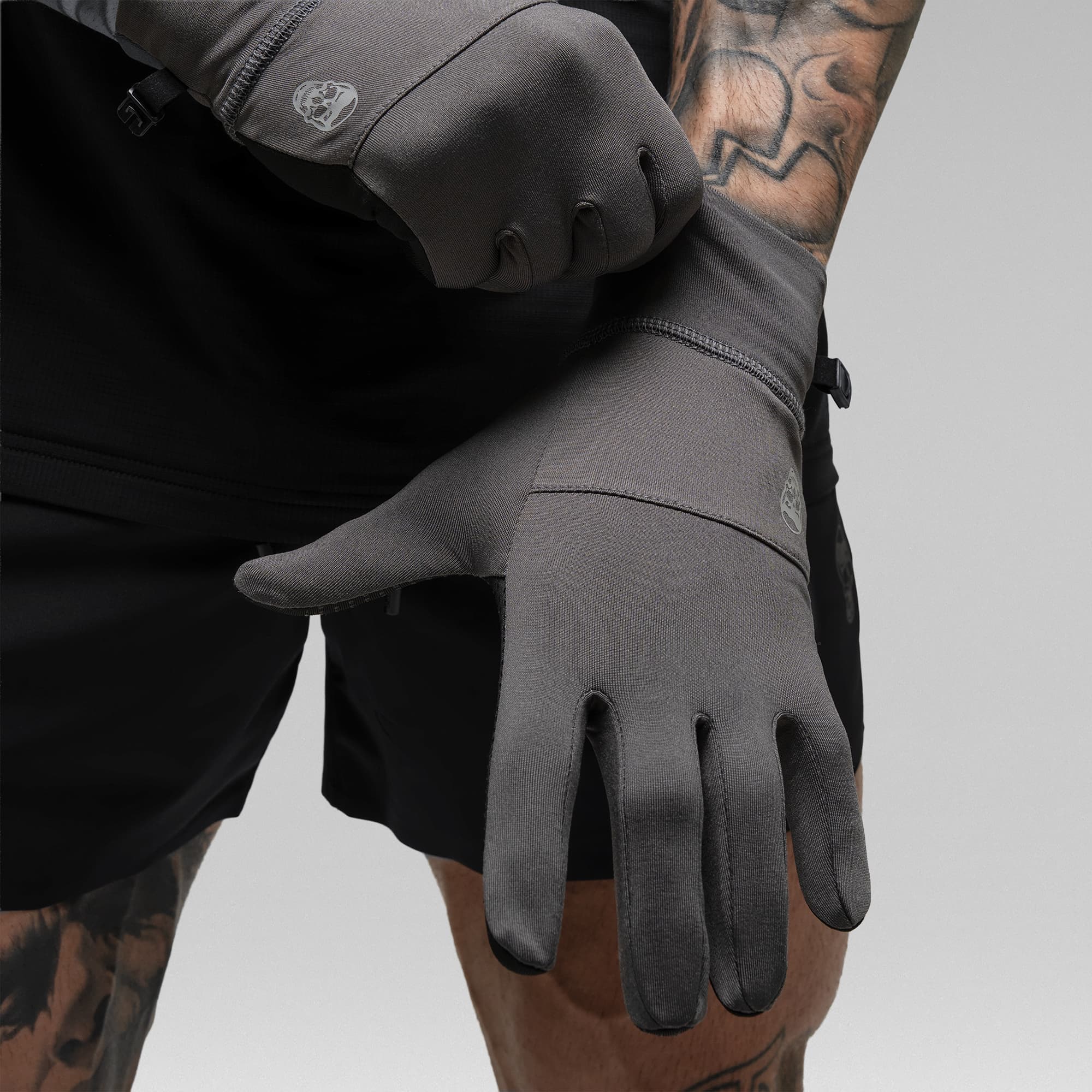 Model putting on the Charcoal Stryda™ Run Gloves