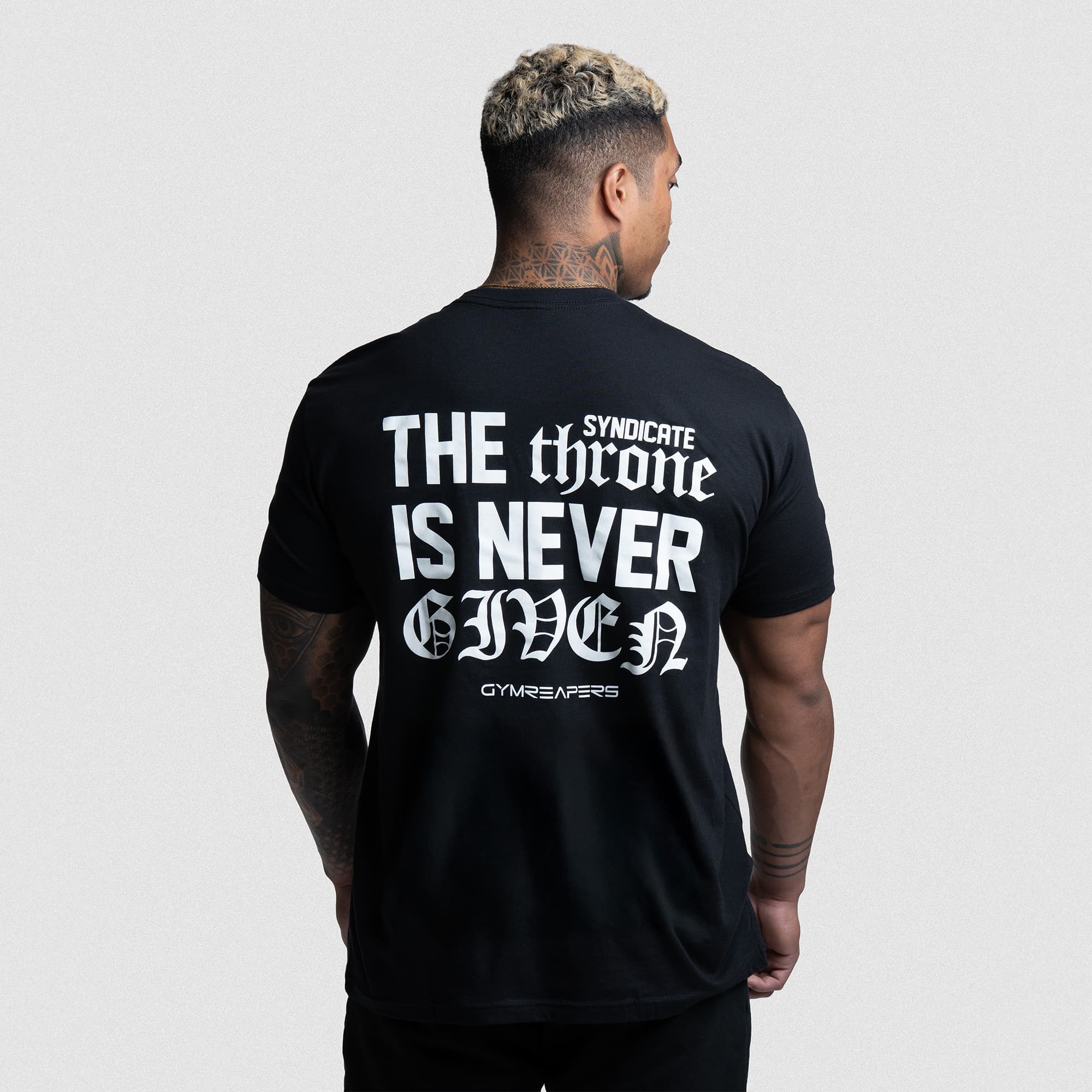 Athlete wearing The Throne Is Never Given Tee showing bold white back graphic.