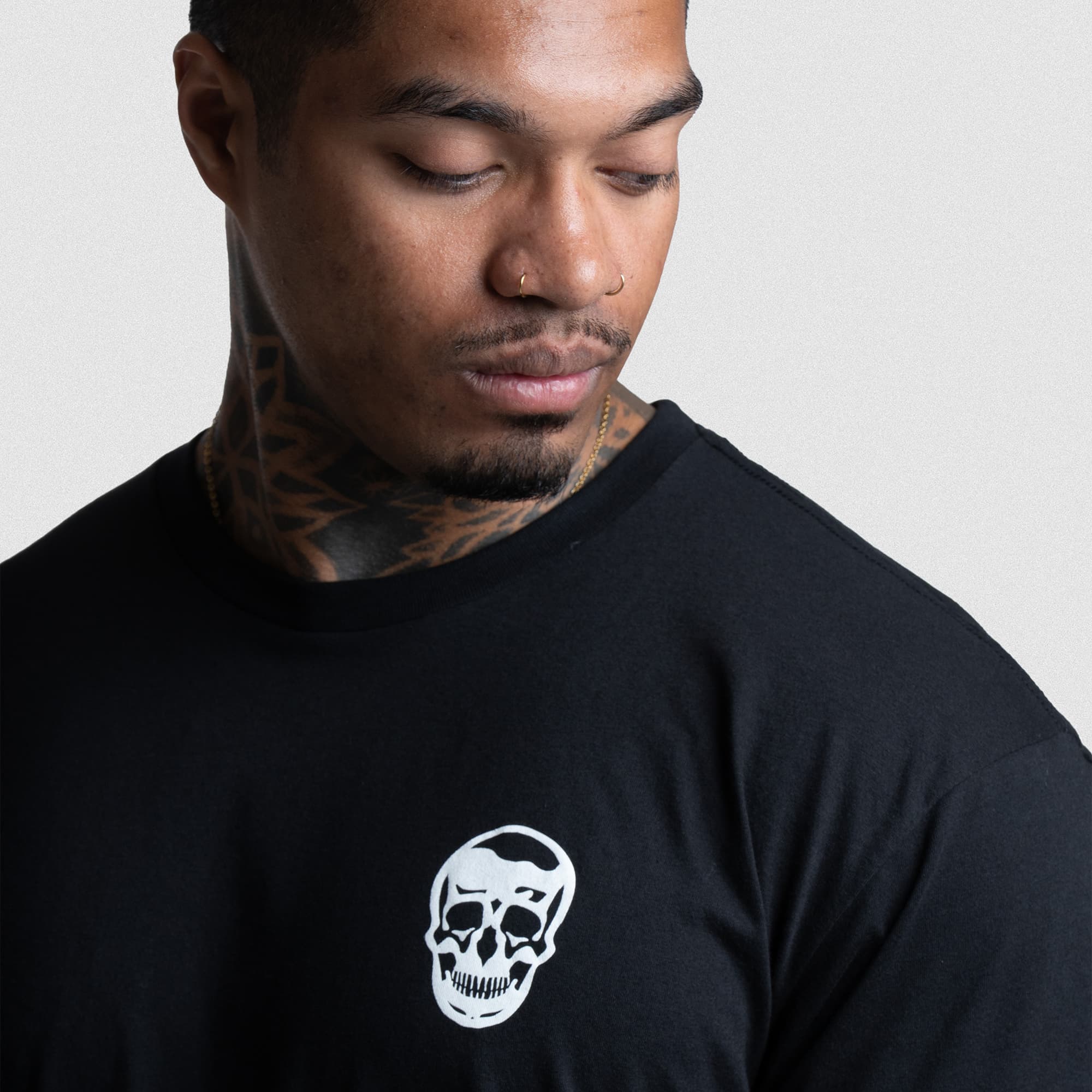 Close-up of Gymreapers skull logo on the front of The Throne Is Never Given Tee.