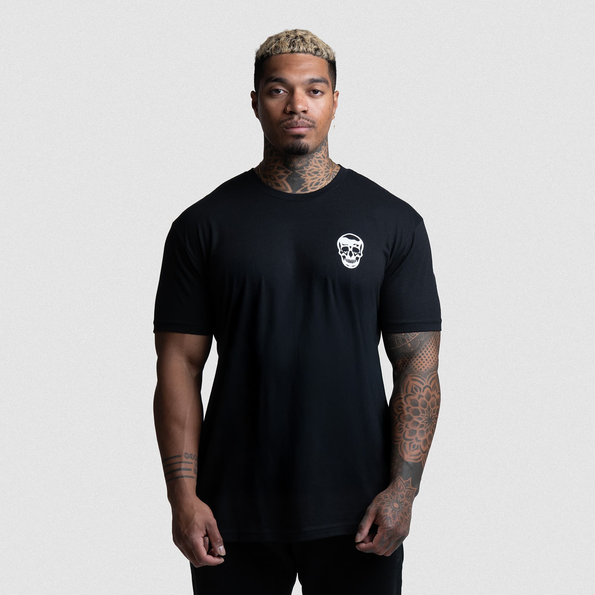 Front view of athlete in The Throne Is Never Given Tee with white skull chest logo.