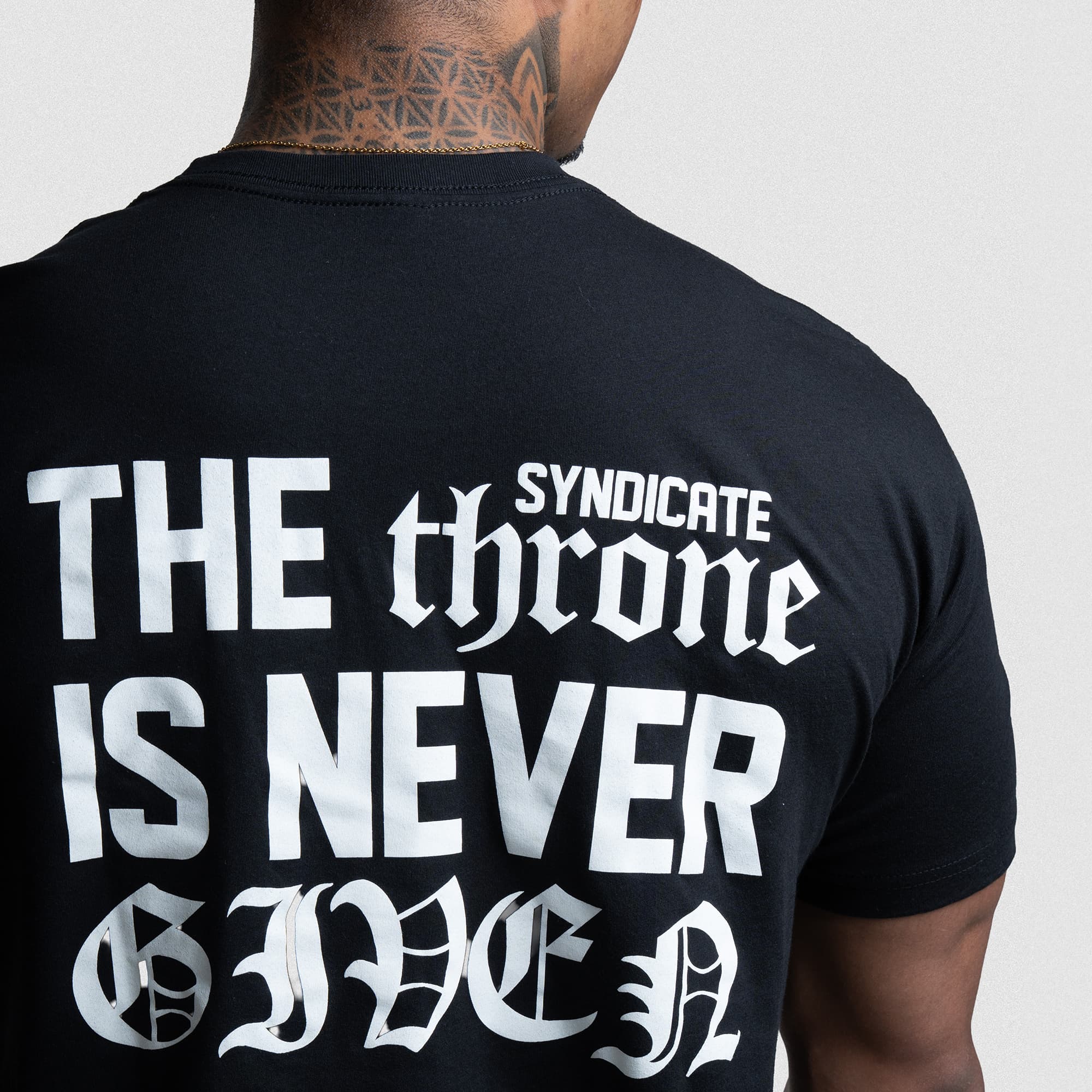 Detailed close-up of The Throne Is Never Given Tee back graphic.