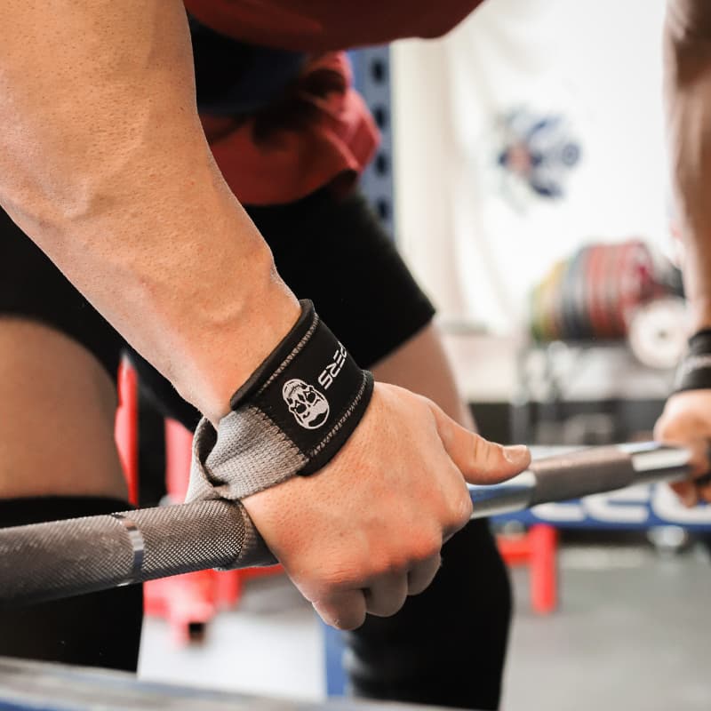 Athlete preparing to deadlift while wearing lifting straps