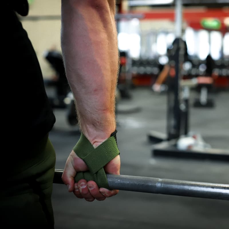 athlete with lifting straps wrapped around bar 