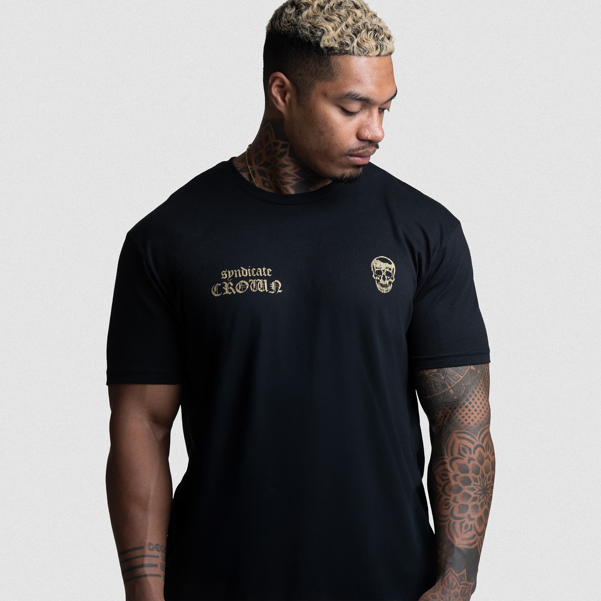 Front view of athlete in Earn Your Crown Tee featuring gold chest print and skull logo.